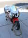 1978 Ford Bronco - Sport motorcycle with red front fender and white fairing is on display stands.
