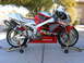 1978 Ford Bronco - A red and silver Honda RVT sportbike is displayed on stands outdoors.