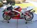 1978 Ford Bronco - A red and silver Honda RVT racing motorcycle is displayed on stands outdoors.