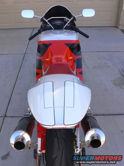 Rear view of a red, white, and black motorcycle with dual exhaust pipes