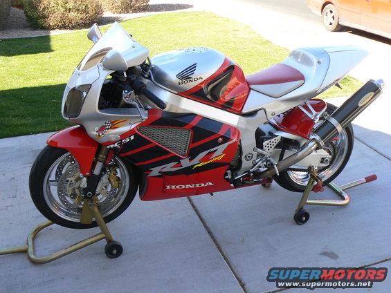 Honda RC51 motorcycle on stands, red and silver fairings, black exhaust