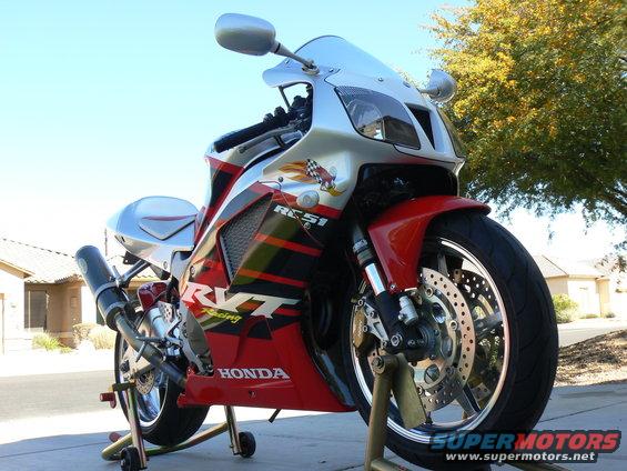 Red and silver Honda sportbike on stands, front view. RVT and RC51 graphics visible