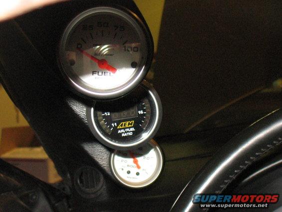 Interior view of three stacked gauges: FUEL, AEM AIR/FUEL RATIO, and a third gauge with a red needle