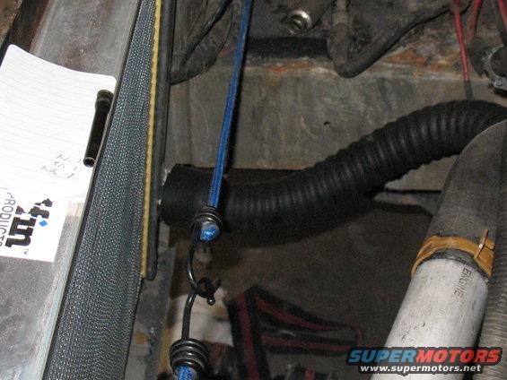 Engine bay with black corrugated hose, white hose labeled ENGINE, blue cord, and a notepad with writing