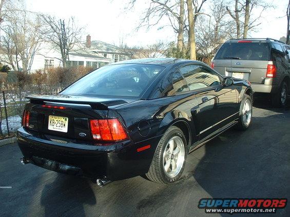 Black 2002 Ford Mustang GT rear quarter view with a gray SUV behind it