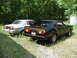 1976 Ford Mustang II - Two 1976 Ford Mustang IIs are parked outdoors in the grass, with trees in the background.