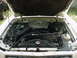 1977 Ford Mustang II - The engine bay of a 1977 Ford Mustang II is visible with the hood open, revealing the V8 engine and surrounding components.