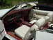 1977 Ford Mustang II - Interior view of a 1977 Ford Mustang II convertible, showing white seats and red trim.