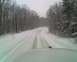1995 Mercury Grand Marquis - A view from inside a vehicle driving on a snow-covered road through a forest.