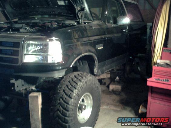 Black SUV with hood open, large tires, and a chrome grille