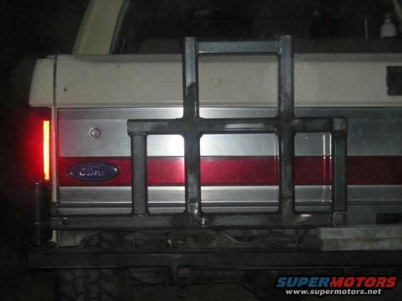 Rear of a white and red Ford Bronco with a custom metal rack attached