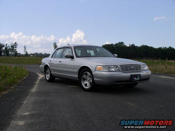 Silver 2001 Ford Crown Victoria sedan parked on asphalt road, front quarter view