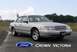 2001 Ford Crown Victoria - A silver 2001 Ford Crown Victoria is shown from the front-right angle on a paved road with trees in the background.