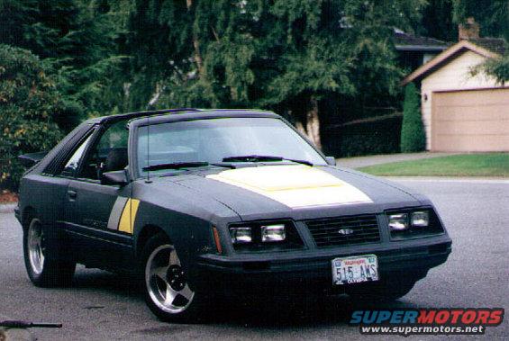 Dark coupe with yellow hood stripe and fender stripes, 3q-front view