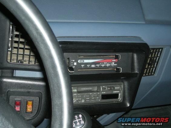 Interior dashboard with steering wheel, climate controls, and radio. Blue dashboard panels