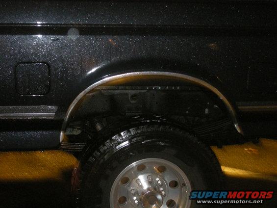1991 Ford Bronco rear wheel well with chrome trim and leaf springs visible
