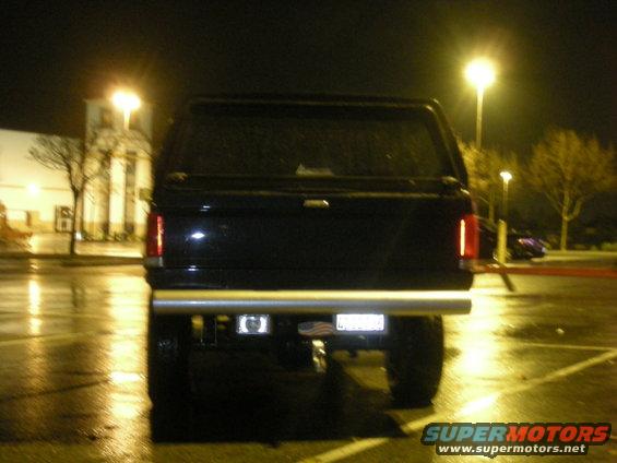 Rear view of black SUV with cap and chrome bumper at night