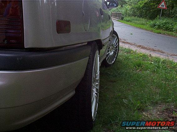 Silver 1990 Mercury Sable wagon rear quarter panel with aftermarket wheels and a black bumper