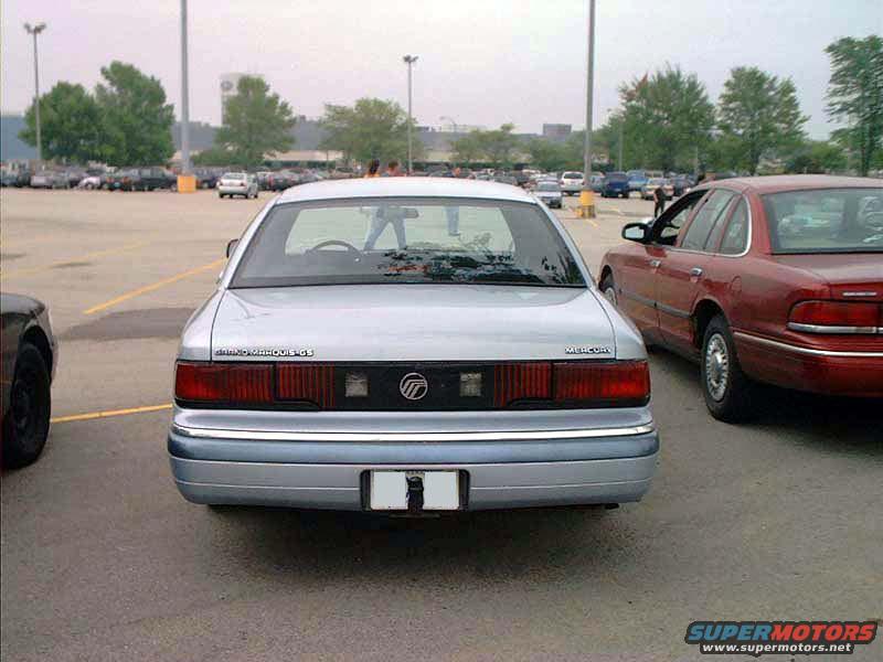 Rear view of a silver 1998 Mercury Grand Marquis LS sedan parked next to a red sedan