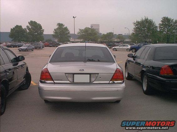 Silver 2000 Ford Crown Victoria parked in a lot, rear view. Chrome trim on bumper and trunk