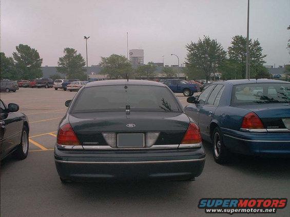 Rear view of a dark green 2000 Ford Crown Victoria parked next to a blue Ford Crown Victoria