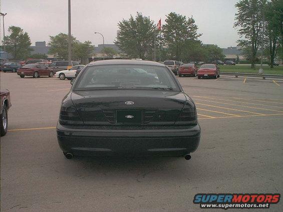 Rear view of a black Ford Crown Victoria parked in a lot. Taillights are tinted