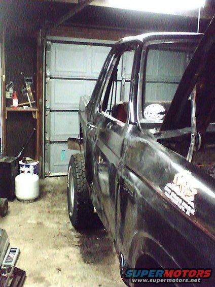 1985 Ford Bronco in a garage, hood up, side view