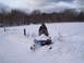 1990 Arctic Cat El Tigre EXT - A snowmobile sits in a snowy field under a cloudy sky.