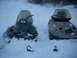 1990 Arctic Cat El Tigre EXT - Two snowmobiles, including a 1990 Arctic Cat El Tigre EXT, are partially buried in snow.