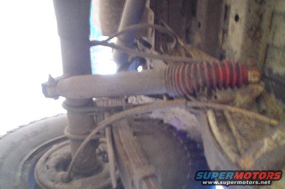 Undercarriage view of a 1979 Ford Bronco showing a shock absorber and leaf springs