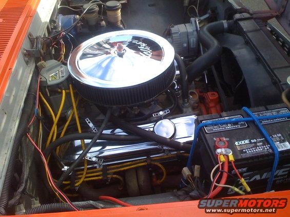 Engine bay with chrome air cleaner, battery, radiator, and wiring