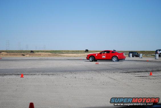 Red sports car with Marlboro logo on side, driving on a track. Visible text: SUPERMOTORS.NET