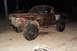 1980 Dodge Magnum - This damaged brown pickup truck, likely from the 1970s, has been modified with large off-road tires.