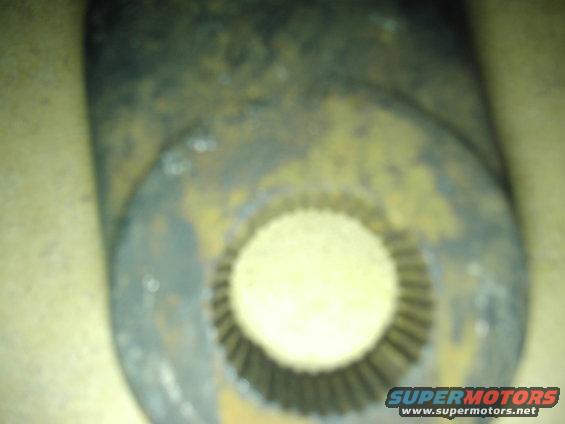 Close-up of a splined shaft end with rust and yellow paint remnants. Supermotors.net logo visible