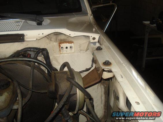 White vehicle engine bay with brake booster and wiring