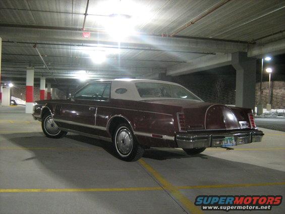 Maroon Lincoln Continental Mark VII with a tan vinyl roof parked in a garage