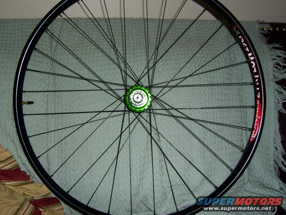 Close-up of a bicycle wheel with a green hub and black spokes