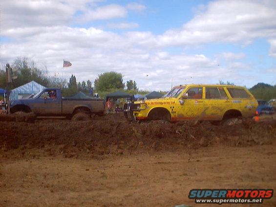 Yellow station wagon and blue pickup truck stuck in mud during a race