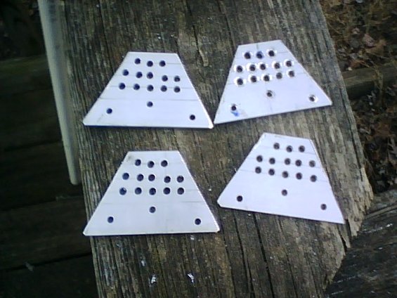 four white triangular plates with black text, resting on a wooden surface