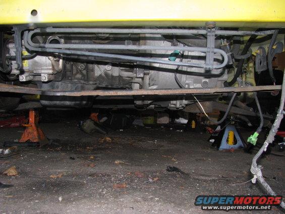 Underside of car on jack stands, showing engine and exhaust components