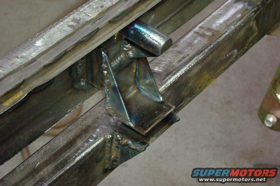 Close-up of welded metal frame components with visible welds and some rust