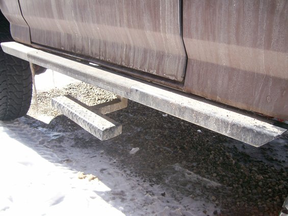 Side step and rear bumper of a brown vehicle