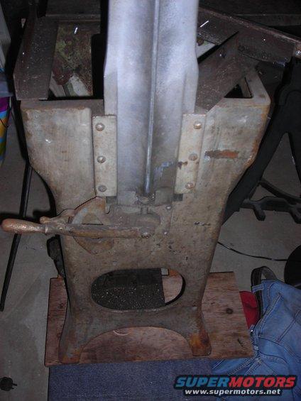 old metal vise with a wooden handle and a lever