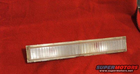 Clear plastic marker light assembly on red fabric