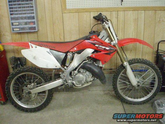 Side view of a red Honda CR dirt bike. Looks like a 2005 model