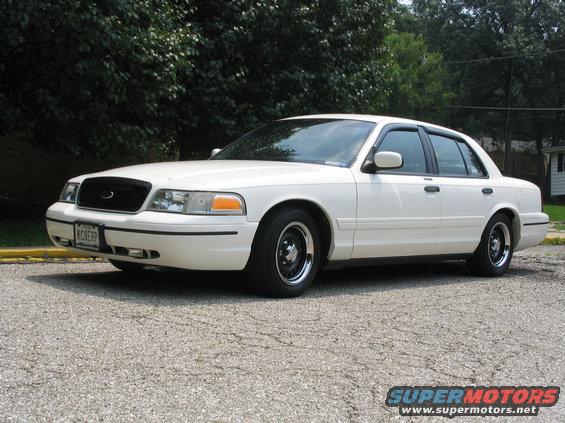 White 1998 Ford Crown Victoria sedan, front quarter view, black grille, chrome wheels, license plate KCBERP