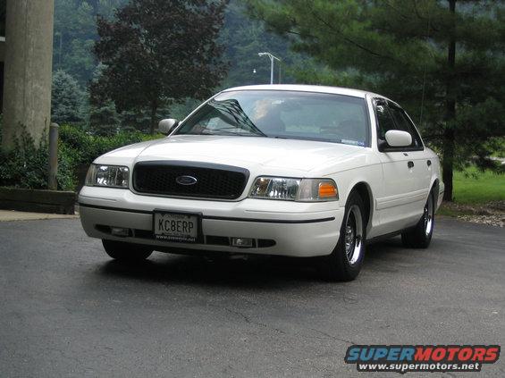 1998 Ford Crown Victoria parked on asphalt, front 3/4 view. Black grille, license plate KC8ERP