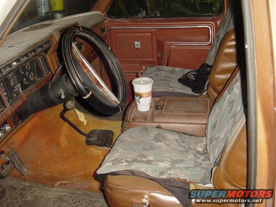 Interior view of brown truck with camouflage seat covers and a cup in the console