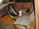 1982 Ford Bronco - The interior of a brown truck features camouflage seat covers and a drink in the center console.