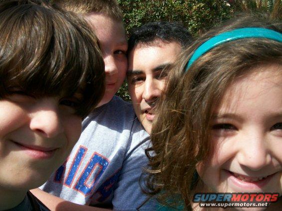 Four people, two kids and two adults, taking a selfie outdoors